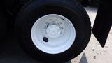 Close-up of a white wheel rim with a six-bolt pattern mounted on a large black tire branded GoodYear C661 HSA