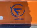Logo of a Fassmer Fast Rescue Boat prominently displayed in blue on an orange surface with some wear and scratches