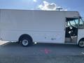 A white 2012 Ford Econoline box truck with no visible branding parked, featuring a driver's side door and large cargo area