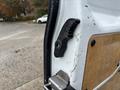 Close-up of the door latch mechanism on a 2019 Ford Transit Connect showing the black plastic handle and metal components
