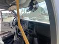 Interior view of a 2020 Chevrolet Express showing the dashboard with controls a steering wheel and a yellow pole next to a fan