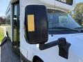 A 2020 Chevrolet Express with a focus on the side mirror which has a yellow adhesive strip on it