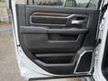 A close-up view of the driver's side door panel of a 2024 RAM 5500 featuring leather trim and control buttons