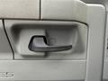 Close-up of the door handle of a 2022 Ford E-450 featuring a simple black design against a textured gray interior surface