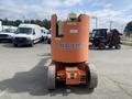 A 2009 JLG E300AJP lift with a distinctive orange body and large wheels facing forward, designed for aerial work and equipment elevation