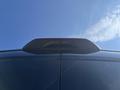 A rear view camera and spoiler atop a black 2025 Ford Transit T-350 van