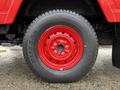 Close-up of a red steel wheel with a black tire on a 2001 Toyota Dyna showing the tire tread and wheel rim details