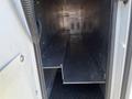 Interior view of a storage compartment in a 2013 Chevrolet Express featuring metal shelving and a sleek design