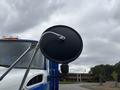 A side mirror of a 2013 International DuraStar 4300 truck with a chrome arm and black circular mirror surface
