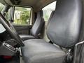 Interior view of the cabin of a 2014 International 7500 showing two cloth seats and the dashboard with controls