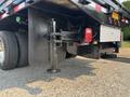 2009 Ford F-450 Super Duty with a flatbed and visible hydraulic jack for stability near the rear wheels and tail lights
