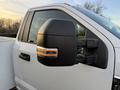A close-up of the side mirror of a 2018 Ford F-350 showing the black housing and integrated turn signal light