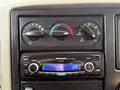 Dashboard controls of a 2012 International 4300 featuring climate control knobs and a Panasonic stereo with an adjustable volume display