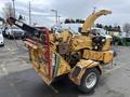 A 2015 Vermeer Corporation BC1200XL wood chipper with a bright yellow exterior featuring a chute on the side and various controls visible on the machine
