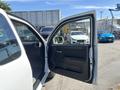 A 2011 Chevrolet Colorado with an open driver's side door showcasing the interior features including the door panel and controls