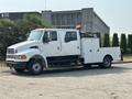 A side view of a 2006 Sterling Acterra truck with a white exterior featuring a utility bed and an orange safety light on the roof