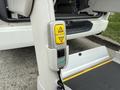 Control panel for a wheelchair lift in a 2009 Toyota Hiace featuring two buttons marked with icons for operation