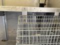 A 2012 Ford Econoline with a metal framework and wire storage racks in the cargo area