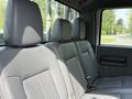 Gray leather interior of a 2011 Ford F-350 SD with three seats in the back row and seatbelts visible