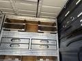 A 2010 Mercedes-Benz Sprinter interior featuring metal storage drawers and shelves organized for utility purposes