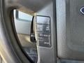 Black steering wheel controls of a 2014 Ford F-150 including buttons for setting and canceling cruise control and resetting information