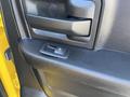 Close-up of the interior door handle and window control switch of a 2015 RAM 1500 in black textured material