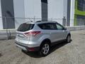 A silver 2014 Ford Escape parked with a sleek design featuring a compact SUV shape and alloy wheels