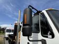 A side mirror of a 2011 International 4300 truck with an orange reflector mounted on a black housing
