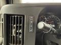 Dashboard controls and air vent from a 2020 Chevrolet Express showing buttons for lights and parking features along with a steering wheel lever
