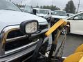 A 2011 Dodge Ram 5500 with a mounted snowplow and a front excavator light in the foreground