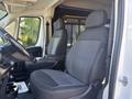 Two gray fabric seats in the front cabin of a 2020 RAM ProMaster 3500 with a black partition behind them