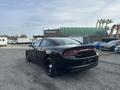 A black 2015 Dodge Charger viewed from the rear showcasing its sleek design and distinctive taillights