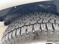 Close-up of a rugged tire with deep treads mounted on a 2020 Chevrolet Express