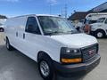 A white 2022 GMC Savana van with a modern design featuring a black front grille and silver wheels