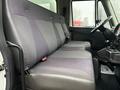 The interior of a 2014 International TerraStar featuring two plush gray seats with seatbelts and a simple dashboard design