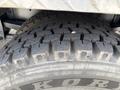 Close-up of a rugged tire from a 2013 Kenworth T370 showcasing deep treads designed for traction and durability