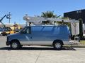 A light blue 2008 Ford E-350 van with a hydraulic lift attached to the roof showcasing a simple design and utility features