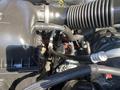 Close-up view of the engine components of a 2015 RAM 2500 showcasing hoses and a black air intake system
