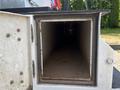 An empty and dusty storage compartment of a 2006 International 4300 truck with a rectangular opening and a dark interior