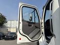 A 2010 Freightliner M2 106 truck door is open displaying a grey interior with a door handle and speaker while the cabin is partially visible inside the vehicle