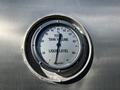 A metallic gauge displaying the total tank volume and liquid level with a needle pointing to approximately 60 percent