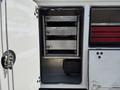 A 2020 Ram 2500 with an open utility door revealing stacked metal drawers and shelves inside