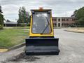 A yellow 2004 Bombardier SW48 with a front plow attachment, designed for snow removal and maintenance tasks, positioned on a paved surface
