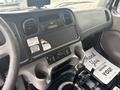 Interior dashboard of a 2006 Freightliner M2 106 featuring controls for audio and climate settings along with a gear shift and a floor mat displaying a message of gratitude