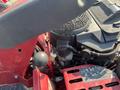 A close-up view of the engine compartment of a 2017 Ferris lawn mower showcasing the engine components and controls in red and black colors