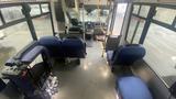 Interior view of a 2021 Ford Transit with blue seating and controls visible at the front