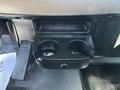 The image shows a cup holder compartment in a 2020 Peterbilt 330 with two circular cup holders and a small control knob in the center