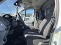A 2017 Ford Transit van showing the driver's side interior with two cloth seats and a dashboard visible