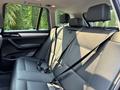 The interior of a 2013 BMW X3 featuring black leather seats with seatbelts in the back row and headrests positioned above each seat