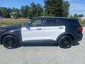 A 2020 Ford Explorer in a two-tone black and white color scheme with black wheels parked on a gravel surface